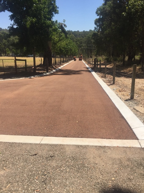 This is a photo of a hot spray & seal bitumen roadway which is in the process of being installed by Yarrambat Surfacing Solutions